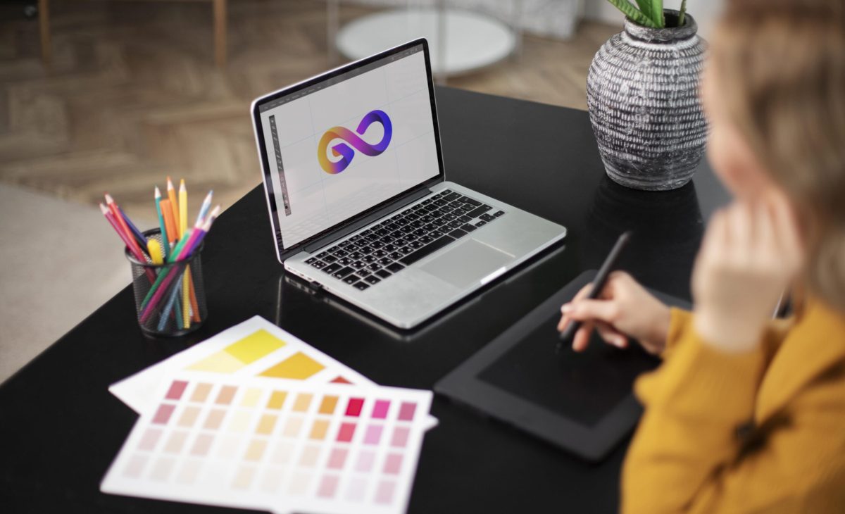 Female logo designer working her tablet connected laptop min