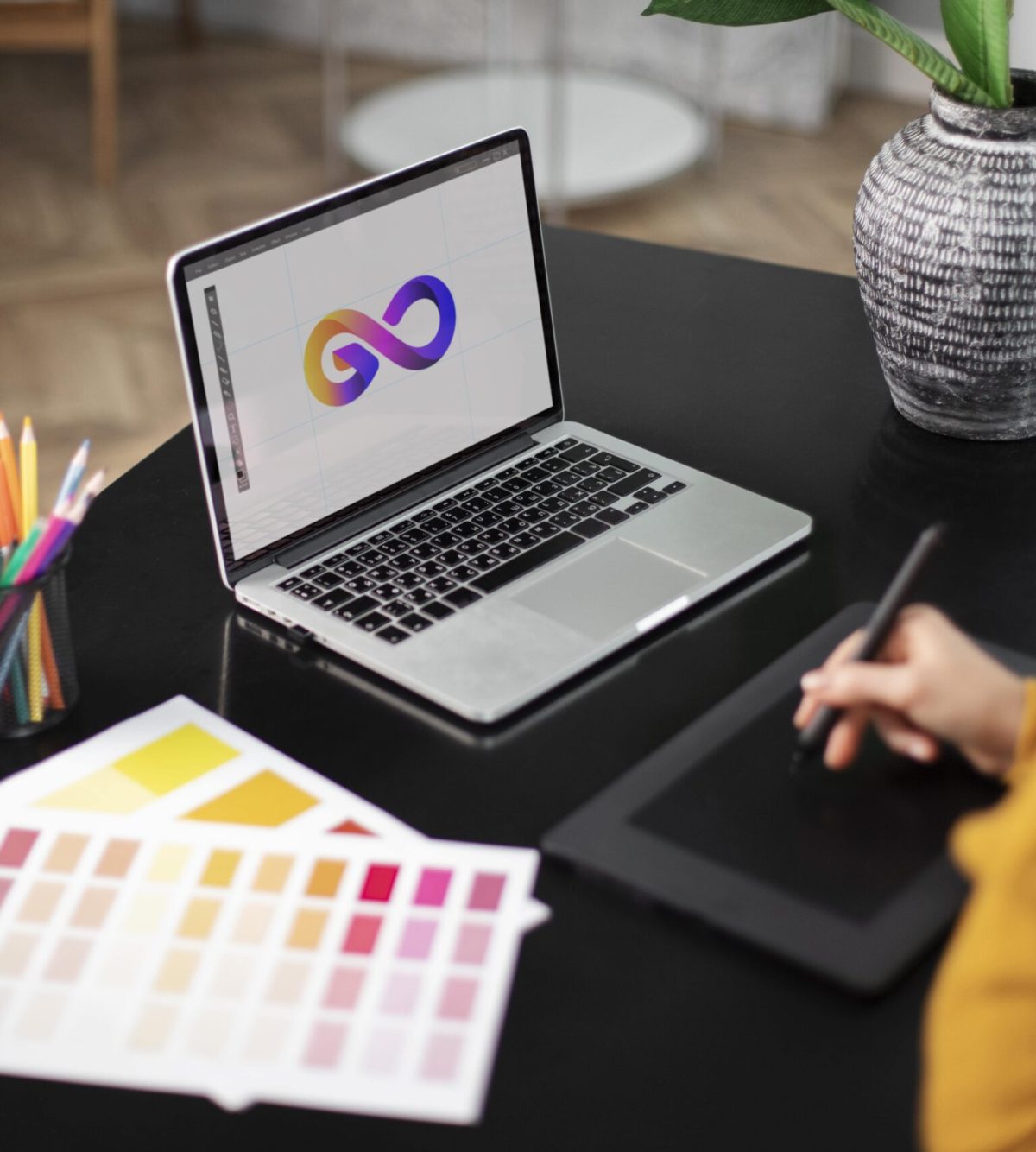 Female logo designer working her tablet connected laptop min